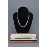 A Chinese vintage graduated jade bead necklace with 9ct gold clasp