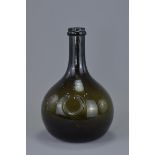 An early 19th century Onion-Shaped dark green glass wine bottle with rounded body. 21cm tall