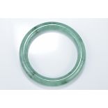 A Chinese pale and green jadeite bangle. 6cm inner diameter