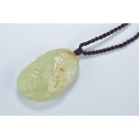 A Chinese celadon and brown jade pendant carved with fish. 5.5cm length