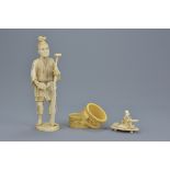 A Japanese Meiji period segmental ivory Okimono of a man with ore and turtle together with a pair of