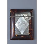 A Victorian tortoise shell card case inlaid with silver and mother of pearl panel. 8cm x 10cm