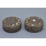A pair of Nepalese / Tibetan white metal filigree boxes and covers decorated with coloured stone ins