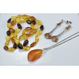 Amber bead necklace together with a pair of silver and amber drop earrings and a silver amber pendan