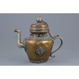 A large Tibetan copper and white metal ewer with cover. Decorated with coloured stones. 29cm tall