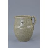 A Chinese Western Jin dynasty (265-316AD) celadon pottery jug with single looped handle. 10cm tall