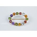 18ct gold multi-gem set brooch consisting of aquamarine, citrine, peridot, amethyst and garnets. 3.5