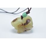 A Chinese carved celadon and brown jade animal pendant. 3.5cm length