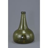 An early 19th century Onion-Shaped green glass wine bottle with rounded body and flat base. 20cm tal