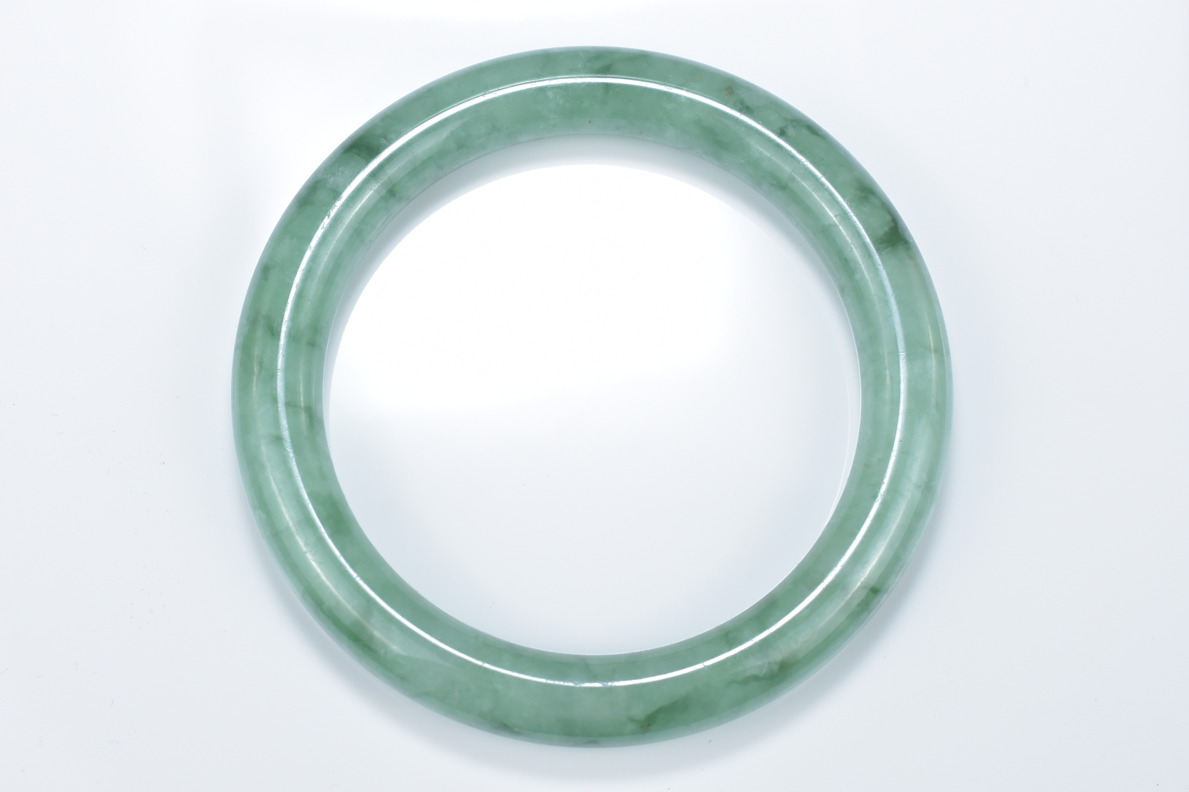 A Chinese pale and green jadeite bangle. 6cm inner diameter - Image 2 of 4