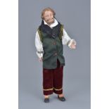 A vintage doll figure of a man in original clothing. 26cm tall