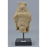 A 19th century possibly Cambodian sandstone carving on display stand. Head 15cm x 9cm