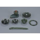 A group of seven Chinese jade items including a pot and cover on stand, a bangle, three dishes, a cu