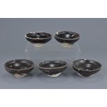 A group of five Chinese Song dynasty (960-1279) black glazed pottery tea bowls. 10Cm diam.