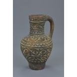 A Persian pottery jug and handle with pattern decoration is relief. 16.5cm tall