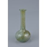 A Roman glass Balsarium with squat spherical body, 4th Century AD. 9.5cm tall. On a later molded dis