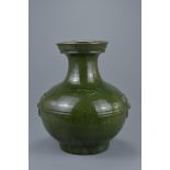 A Chinese Han dynasty (206 BC - 220 AD) dark green glazed pottery Hu jar with twin taotie masks in r