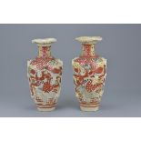 A pair of Japanese 19/20th century pottery vases decorated with figures and molded tassel handles. 2