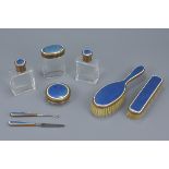 A set of eight English early 20th century guilloche enamel and glass vanity set. (8)