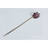 An antique yellow metal with flat cut garnet cluster tie pin. 68mm length