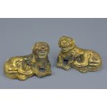 A pair of Chinese gilt bronze figures of resting lions. 18cm length. 1696 grams and 1646 grams (2)