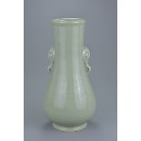 A Chinese 18th century celadon glazed bottle vase with elephant handles. Qianlong seal mark to base