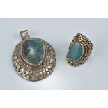 One Tibetan white metal pendant with large turquoise coloured stone insert with floral decoration in