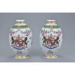 A pair of 19/20th century French porcelain tea caddies with armorial crests and Famille rose decorat