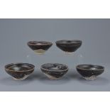 A group of five Chinese Song dynasty (960-1279) black glazed pottery tea bowls. 10Cm diam.