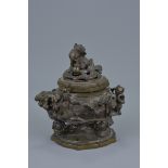 A 19/20th century Japanese cast bronze incense burner and cover surmounted with Dog of Fo. Three-cha