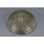 A large Middle Eastern metal shield of circular convex form with engraved decoration of figures and