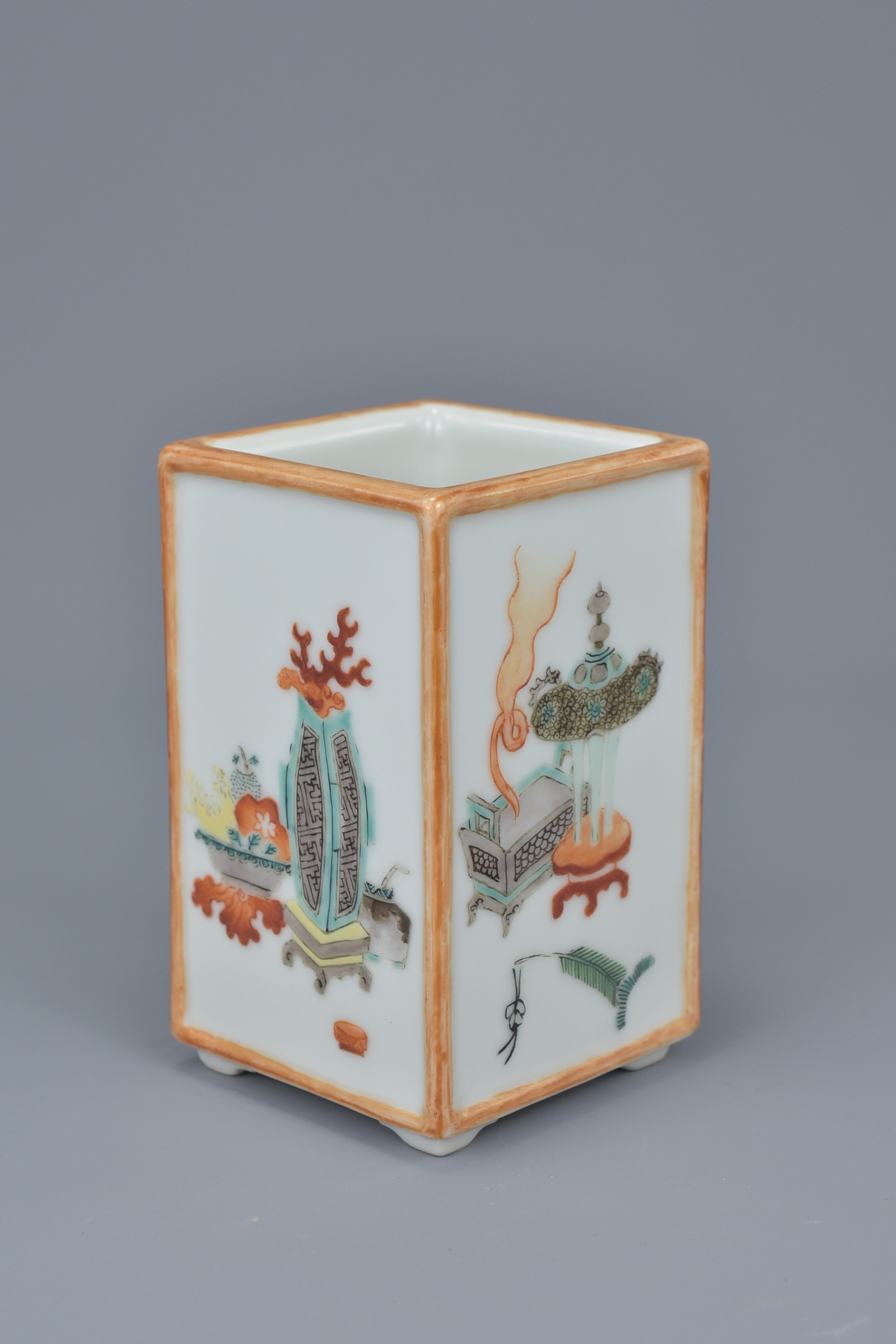 A Chinese late 19th century porcelain brush holder. Each side painted with Scholars objects. Inscrip