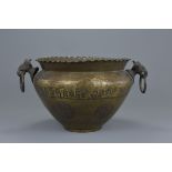 A large Indo-Persian brass pot with elephant mask looped handles and engraved animal decorations. 38