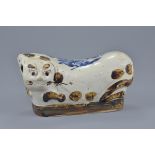 A Chinese 19/20th century glazed and painted pottery pillow in the form of a cat. 25cm length