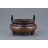 A quality Chinese 19th century bronze tripod censer with twin looped handles. Silver wire inlay of a