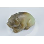 A Chinese pale green and brown jade carving of a seated bear. 8Cm length