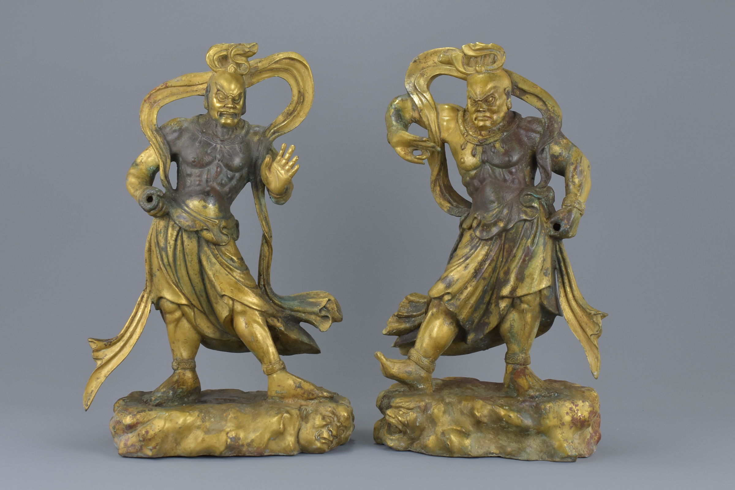 A pair of Chinese gilt bronze figures of Guardians standing on Mythical beasts. 37cm tall 4882 grams