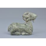 A Chinese Han dynasty or later cast bronze figure of a recumbent ram with it's legs tucked under its