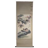 A Chinese watercolour painting on paper in scroll with wooden handles of two cats lying under a tree