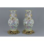 A pair of 19th century Chinese Cantonese porcelain vases decorated with figures in garden scenes wit