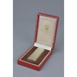 A Cartier Paris silver-plated lighter in original display box. Serial number 34584 A. 7Cm length.