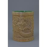 A Chinese porcelain brush pot carved with dragon