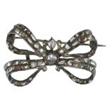 An antique white metal (unmarked) and old cut diamond bow brooch