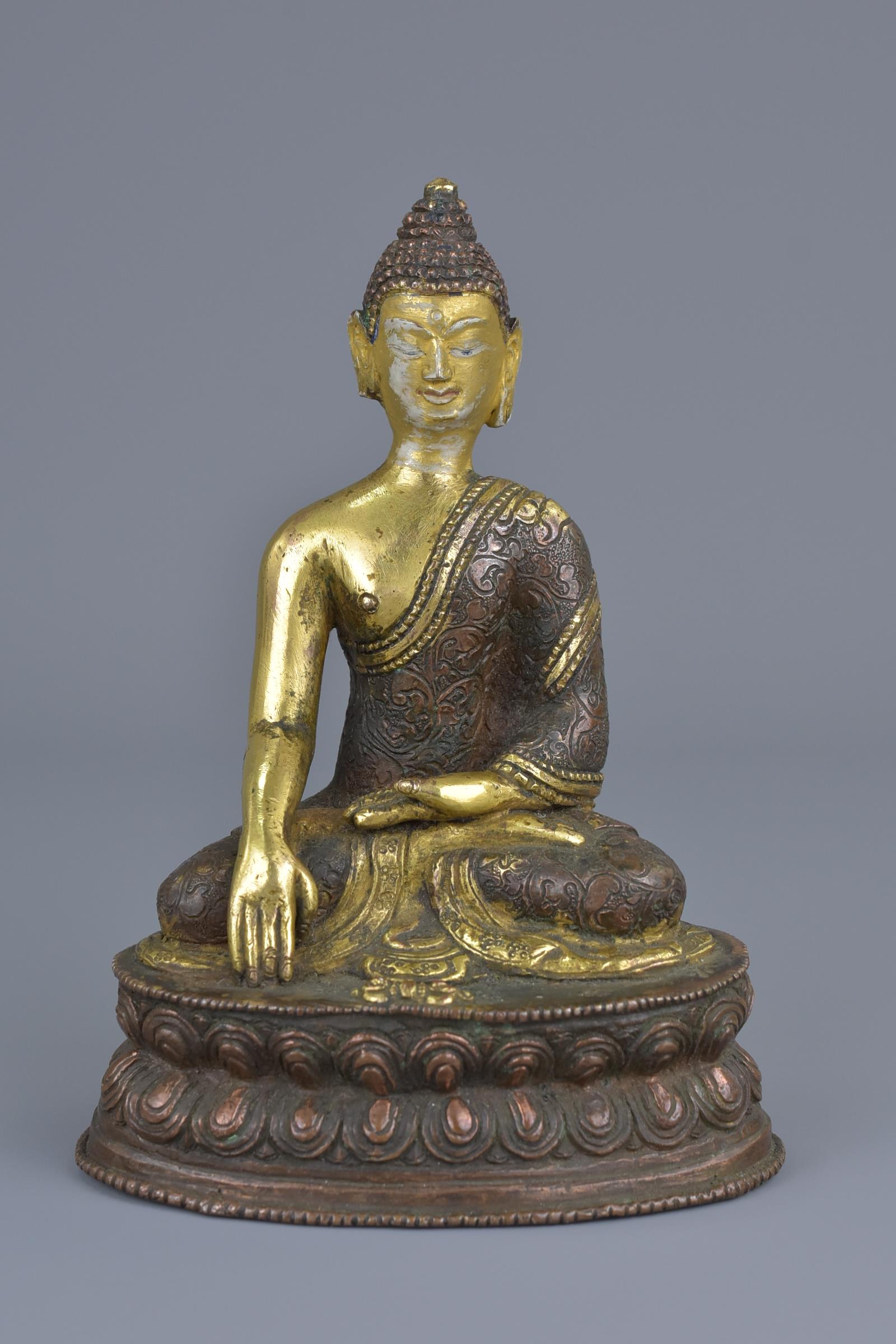 A Tibetan gilt bronze figure of a seated Buddha