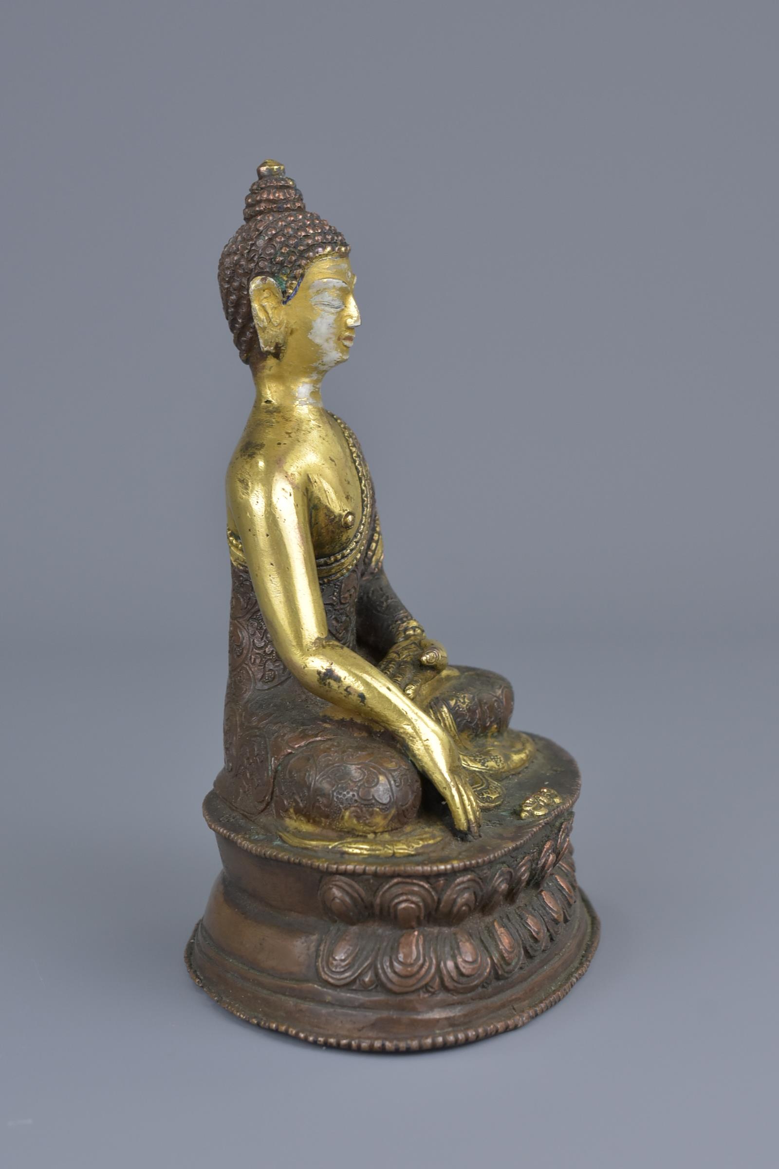 A Tibetan gilt bronze figure of a seated Buddha - Image 4 of 7