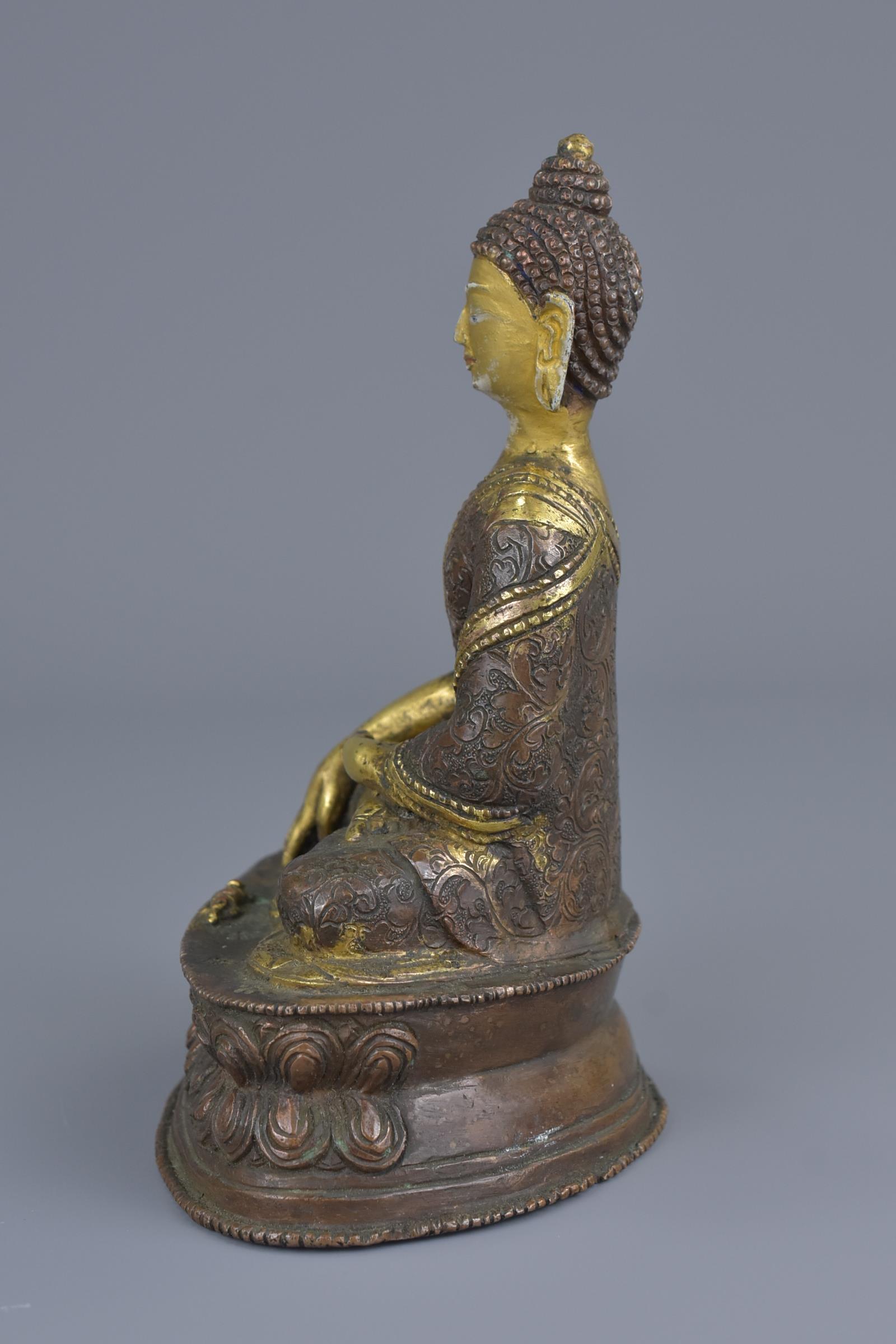 A Tibetan gilt bronze figure of a seated Buddha - Image 2 of 7