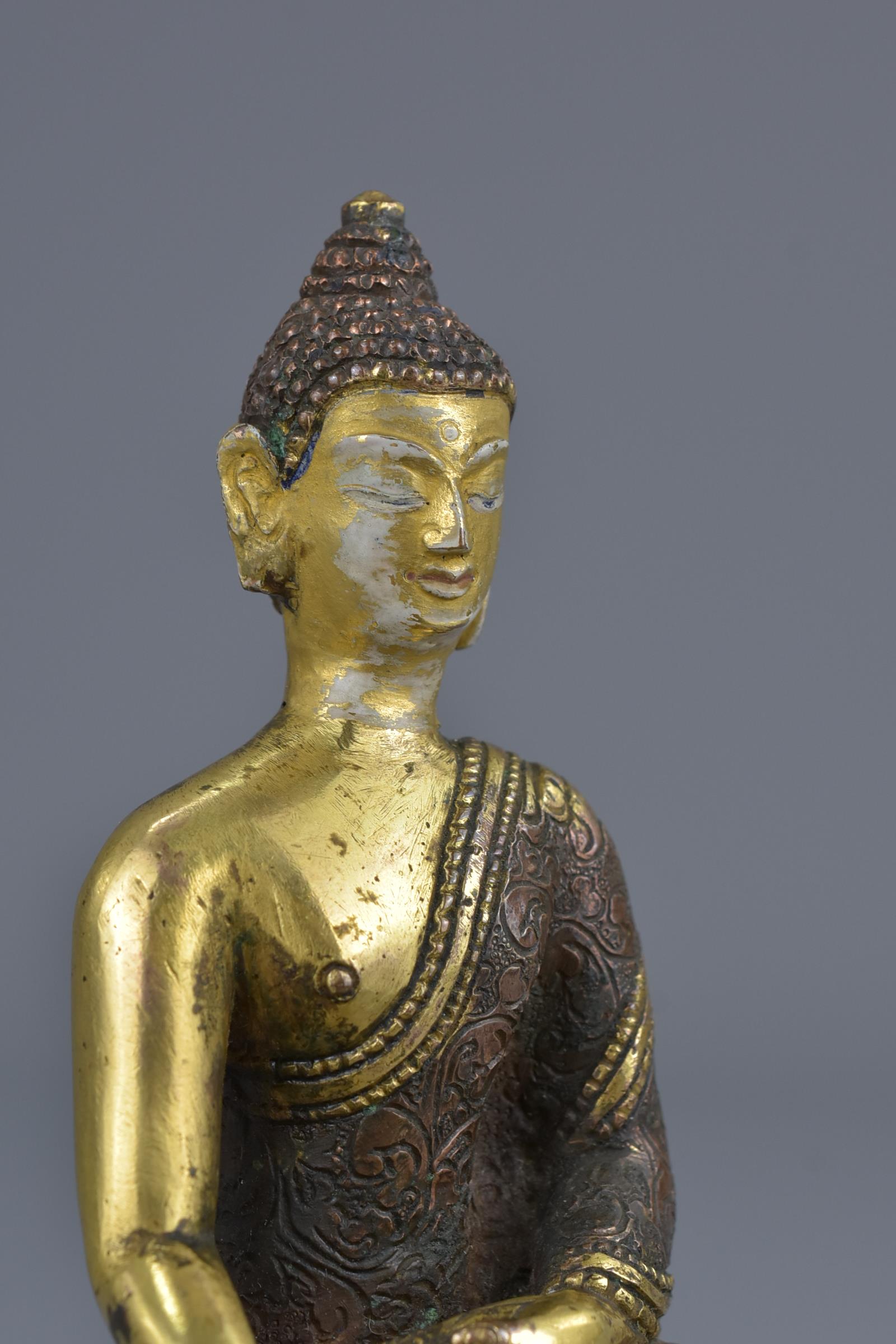 A Tibetan gilt bronze figure of a seated Buddha - Image 7 of 7