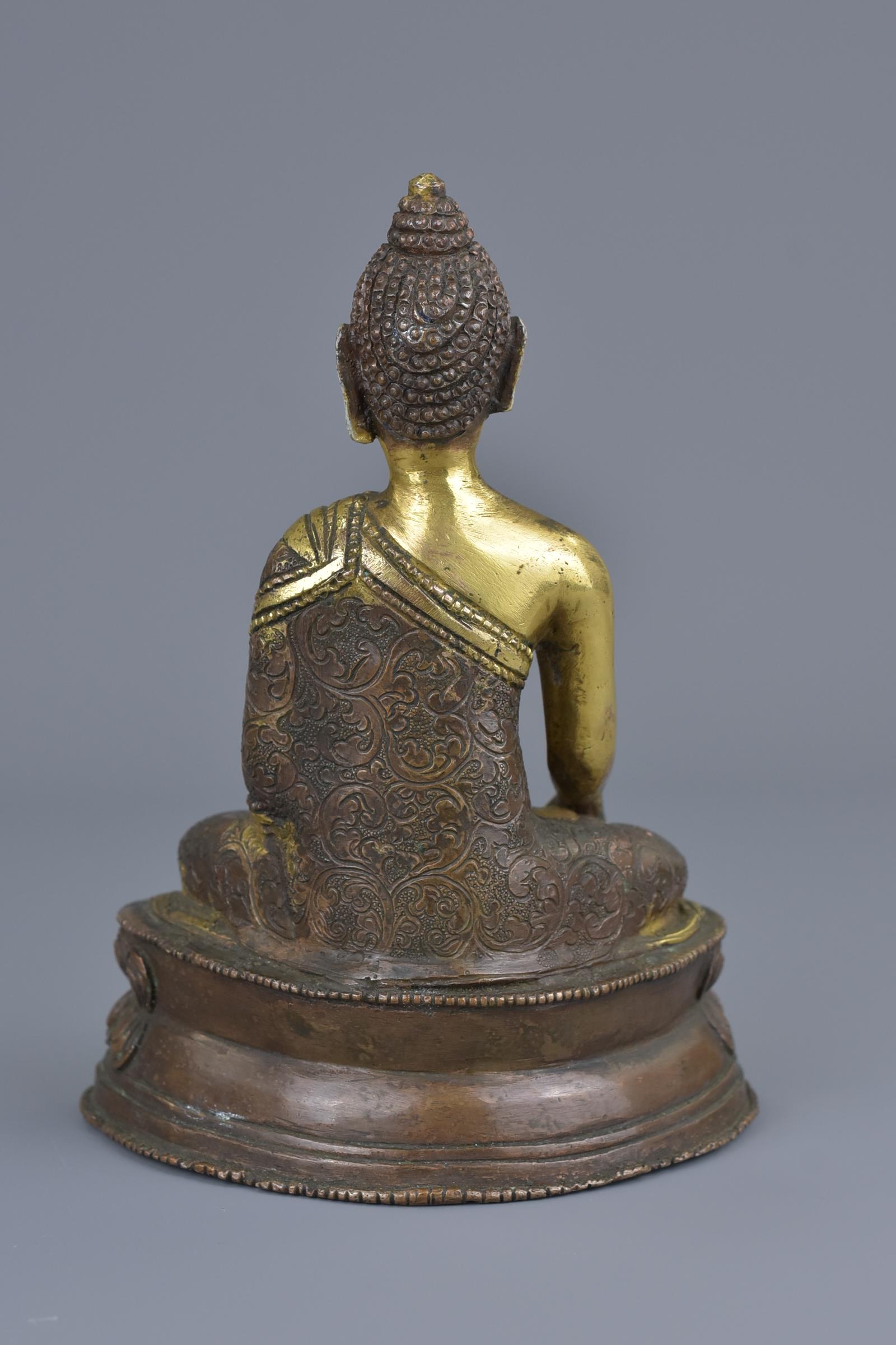 A Tibetan gilt bronze figure of a seated Buddha - Image 3 of 7