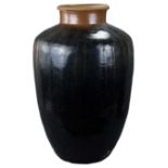 A large Chinese Yuan / Ming Dynasty black glazed pottery storage jar, 80cm tall