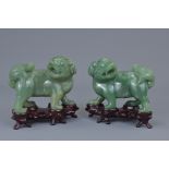 A pair of Chinese 19th C. carved jade lions on wooden stands